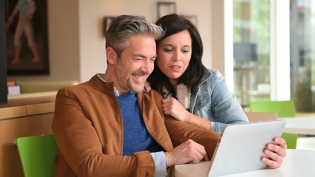 Mature couple in coffee shop connected on internet