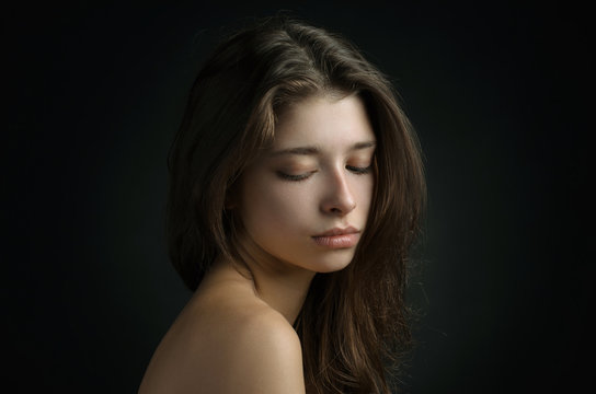 Dramatic portrait of a girl theme: portrait of a beautiful girl on a background in the studio