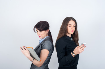 Two business women standing backs to each other