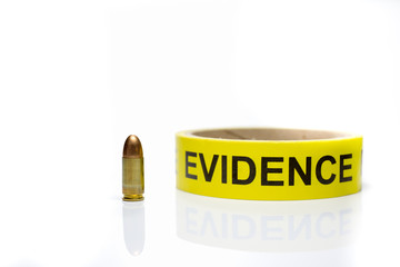 evidence tape with 9 mm bullet  on white background