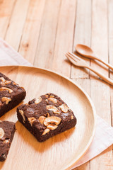 Chocolate brownie cake served on wooden plate.Selective focus on flork.