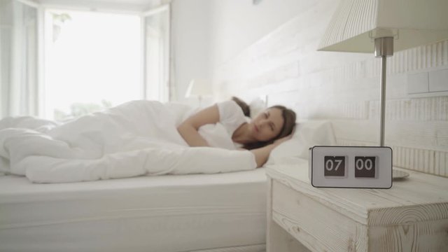 4k footage, alarm clock ringing, young couple in bed continue to sleep, focus on alarm
