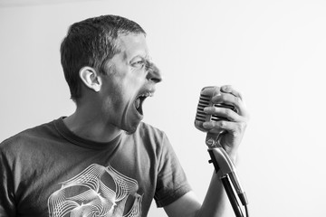 Young caucasian man shouting in to the microphone
