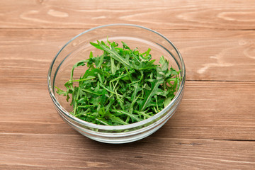 Fresh green arugula leaves in a glass bowl