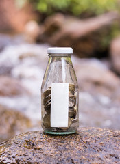Saving coins in the glass jar.