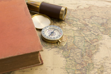 Fototapeta na wymiar Old book and old spyglass and old compass on vintage map world discovery concept