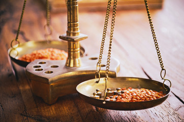 Vintage balance scales with two pans and masses weighing red lentil