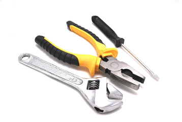 Гаечный ключ плоскогубцы отвертка на белом фоне крупным планом