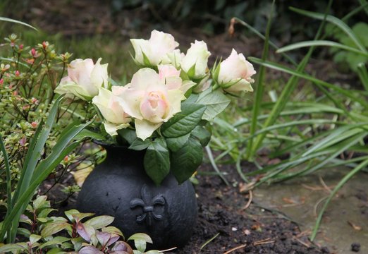 Helle Tulpen in runder Vase auf dem Friedhof mit Textfreiraum