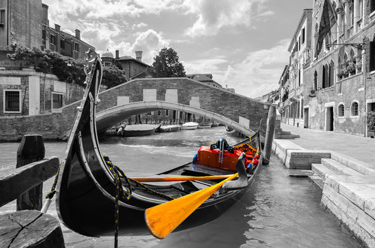 Fototapeta Black and white of a beautiful canal in Venice with selective color on the gondola