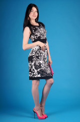 Fototapeta premium Beautiful young girl posing in street clothes on blue background.Isolated studio portrait