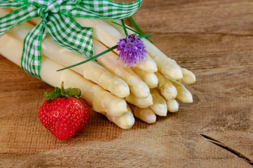 Gebundener roher weißer Spargel auf einem Holztisch