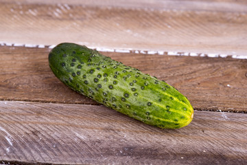 green cucumber on old boards