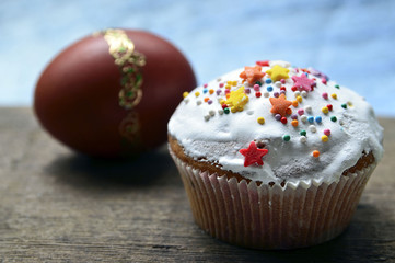 Easter cake and egg on wooden table with selective focus.