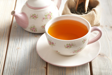 Cup of tea and teapot on wooden table