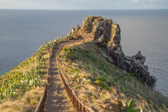 Christusstatue auf mit Kakteen bewachsenem Felsvorsprung Cristo Rei auf Madeira und h&ouml;lzerne Treppe auf den Felsvorsprung