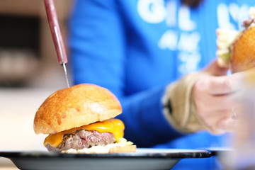 Woman eating cheeseburger