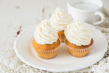 Vanilla cupcakes on white wood background