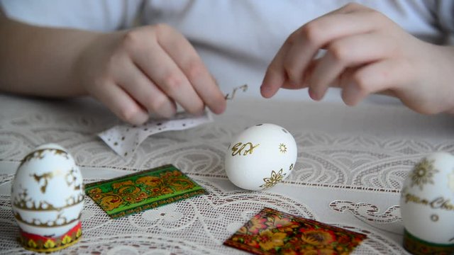 Boy sticks stickers on  Easter eggs