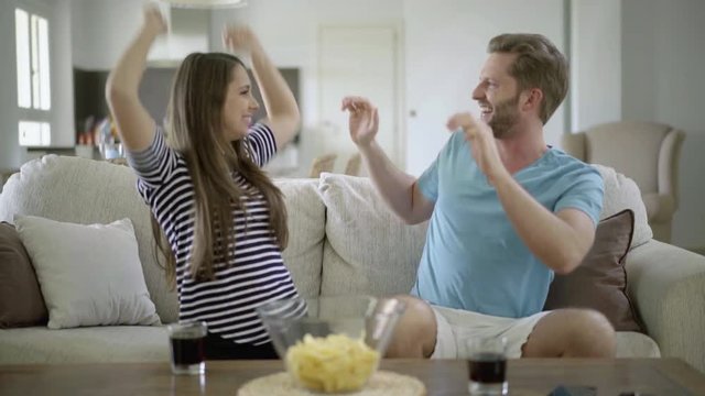 4k footage, soccer fan couple watching tv at home disappointed with referee desicion

