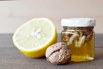 Jar of honey with walnuts and lemon