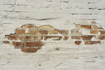 Brick red wall shines through the cracked plaster,  background