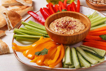 Homemade hummus with assorted fresh vegetables and pita bread.