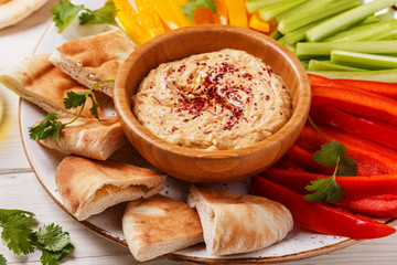Homemade hummus with assorted fresh vegetables and pita bread.