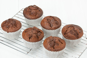 Homemade Chocolate Muffins In Paper Cases. White Table.