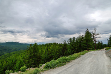 Fototapeta na wymiar gravel road in a mountain valley at the top of the Altai Mountains Summer