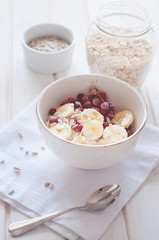 Fototapeta na wymiar Healthy breakfast. Oatmeal with bananas, cranberries and sunflow