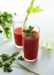 Tomato juice in glasses on white backround