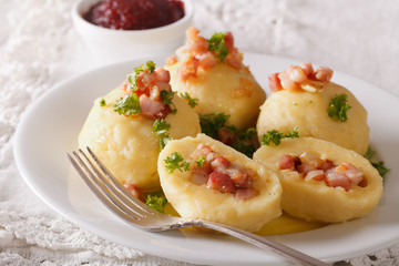 Potato dumplings stuffed with ham and onion close-up and lingonberry sauce. horizontal
