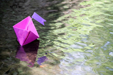Papierschiff schwimmt im Bach