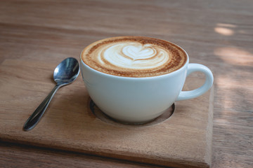 A cup of cappucino on a wood background