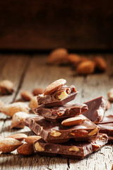 Milk chocolate with whole almonds, vintage wooden background, se