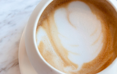 A cup of cappucino on a white table