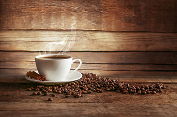 Tasse Kaffee mit Körnern auf hölzernem Hintergrund