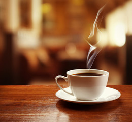 Cup of coffee on table on blured cafe background