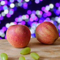 Closed up new and fresh apple and grapes on wood background