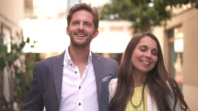 4k footage, closeup young well dressed couple walking through narrow street of old town
