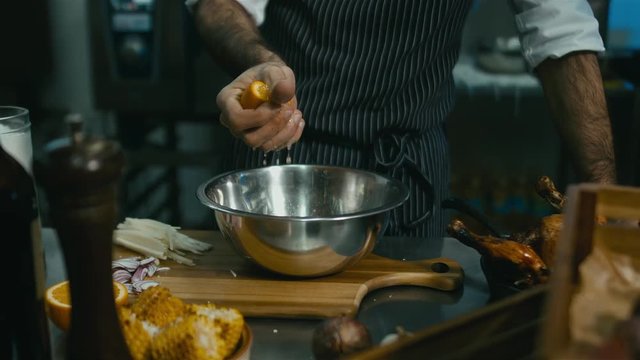 Restaurant Chef squeezing an orange into a salad dish. 60 FPS slow motion shot. Blackmagic URSA Mini