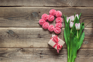 Background with a bouquet of tulips, gift box and a heart shape