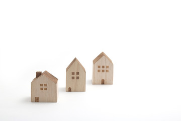 Miniature houses on white background. Building blocks arranged in row.
