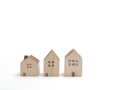 Miniature houses on white background. Building blocks arranged in row.