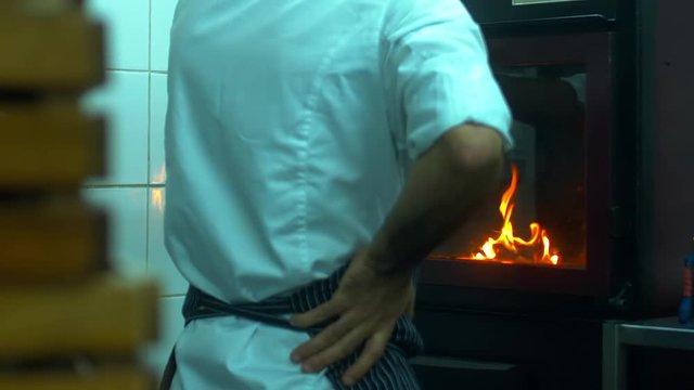 Restaurant chef looking on the fire in the oven. 120 FPS slow motion shot. Blackmagic URSA Mini