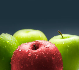 Red apple laying in group of green apples