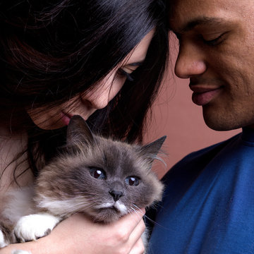 Woman Kissing A Cat With Her Man