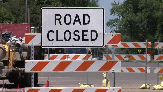 Two shots of same scene (one medium, one wide) showing a road closed due to construction. Features "Road closed" signs.