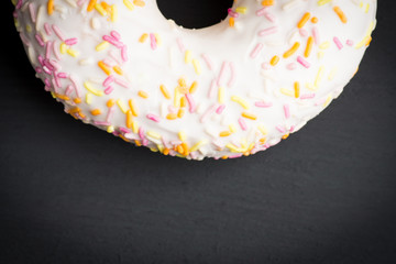 Donut with sprinkles on the black background